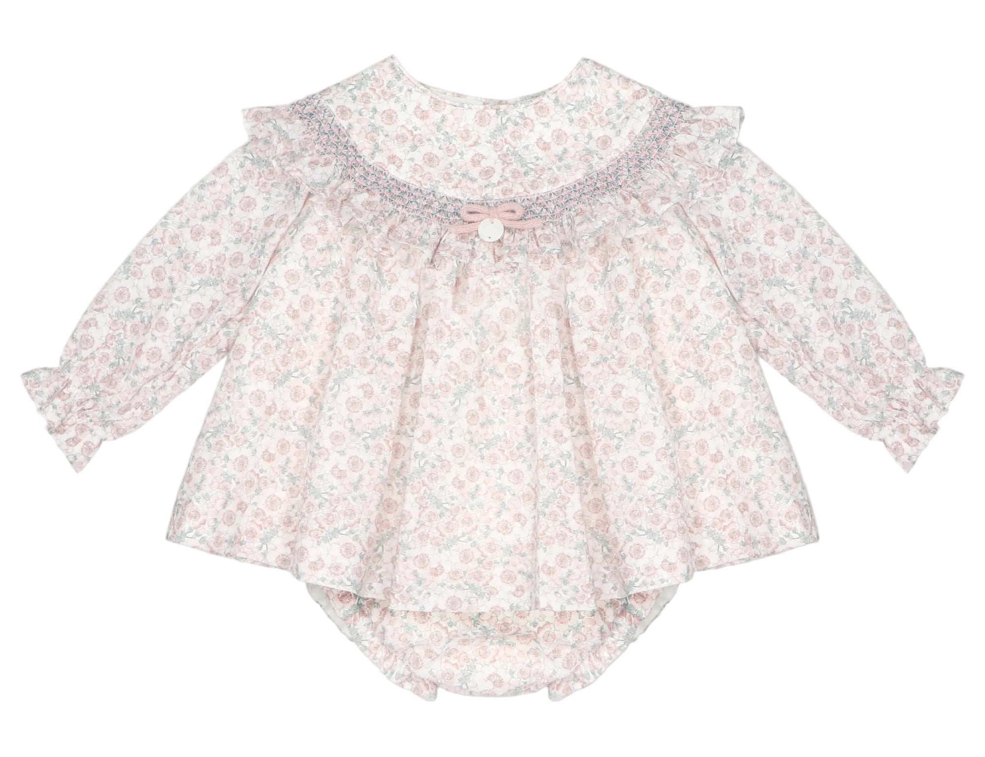 A baby girl's long-sleeve romper in a light pink and white floral print, featuring a ruffled collar with a small bow accent, photographed on a neutral light gray background.