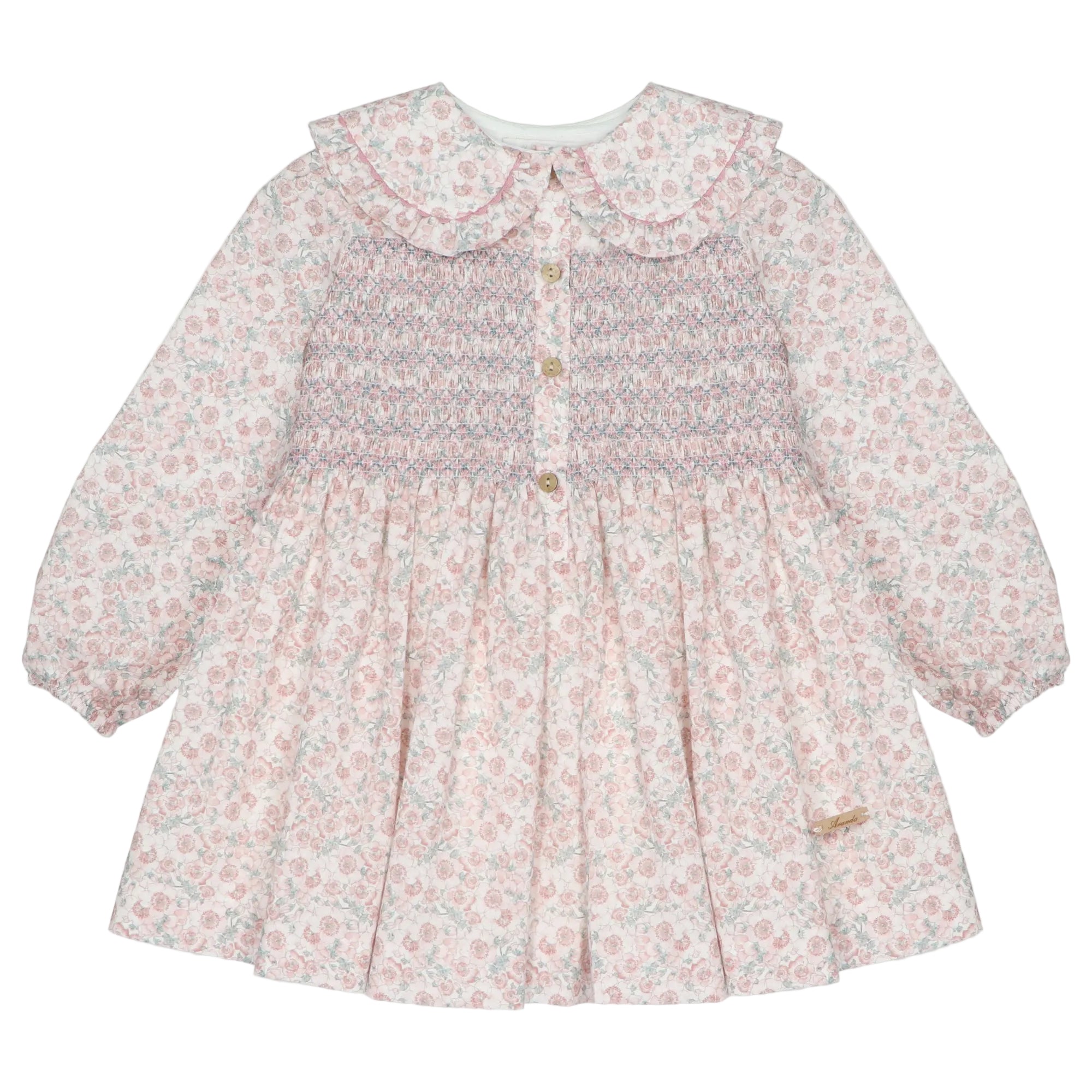 A long-sleeve baby girl's dress with a pink and white floral print, featuring a smocked bodice with gold buttons and a large ruffled Peter Pan collar.