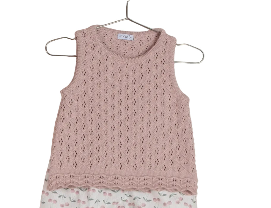 Pink sleeveless top with floral shorts on a hanger against a light pink background