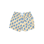 Pair of shorts with blue shell pattern on a beige background