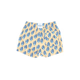 Pair of shorts with blue shell pattern on a beige background