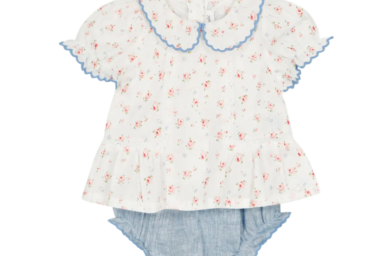 Floral blouse with ruffled collar and denim shorts on a white background